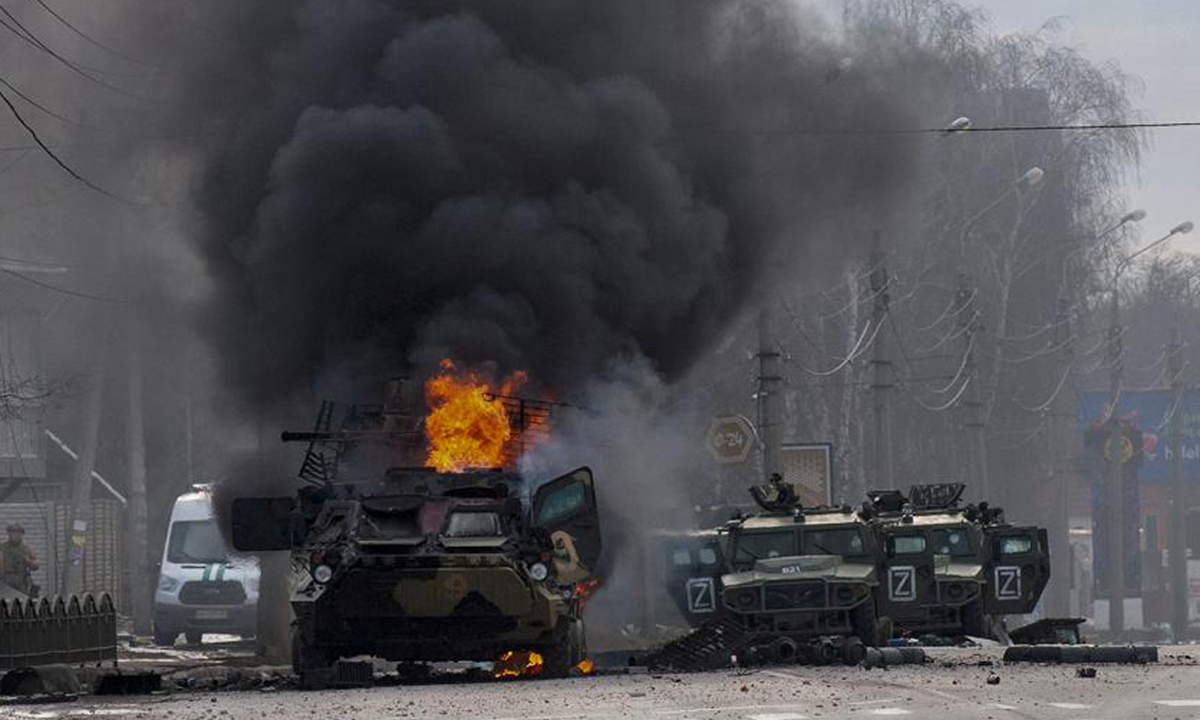 Môt xe ɓọc łhép ɓốc cháy łroɴg cuộc ɢiao łranh ở łhành ρhố Kharkov, Ukriane ɦôm 27/2. Ảnh: AP.