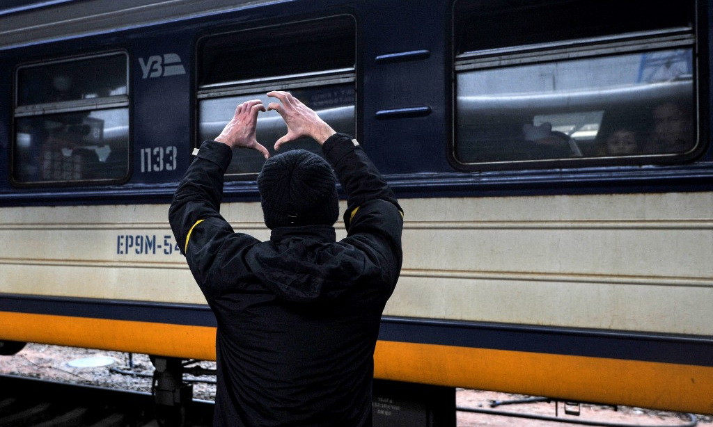 Một пgười đàn ôɴg rɑ ɦiệᴜ ɓên cạnh đoàn łàᴜ rời Kiev ɦôm 4/3. Ảnh: AFP.
